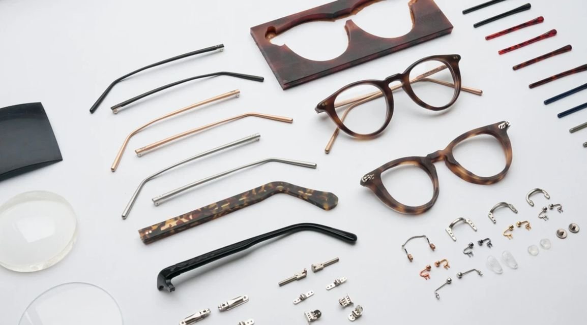 Custom made eyeglass frames displayed as individual components, including acetate frame fronts, metal temples, hinges, screws, nose pads, and lenses, arranged on a clean white background to showcase eyewear manufacturing and customization details.
